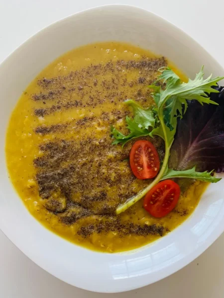 instant pot lentil soup recipe vegetarian in a white bowl with brown lentils, red lentils, carrots, and wilted spinach in clear broth