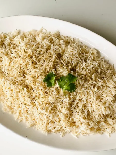 instant pot mexican rice with fluffy red tomato grains, cilantro, and onion in a white bowl