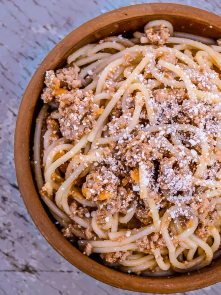 instant pot spaghetti recipe one pot with tender noodles in red tomato beef sauce topped with parmesan in a steel insert