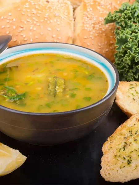 instant pot vegetable soup recipe healthy with carrots, celery, kale, and tomatoes in clear broth in a white bowl