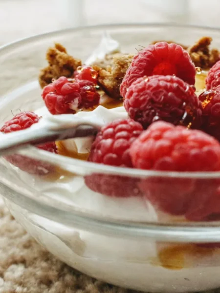 instant pot yogurt recipe homemade in a glass bowl with thick white yogurt and a spoon on a marble counter