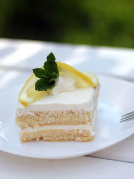 lemon cream cake with saffron glaze showing golden saffron topping, white cream layer, and lemon zest crumb on a round slice