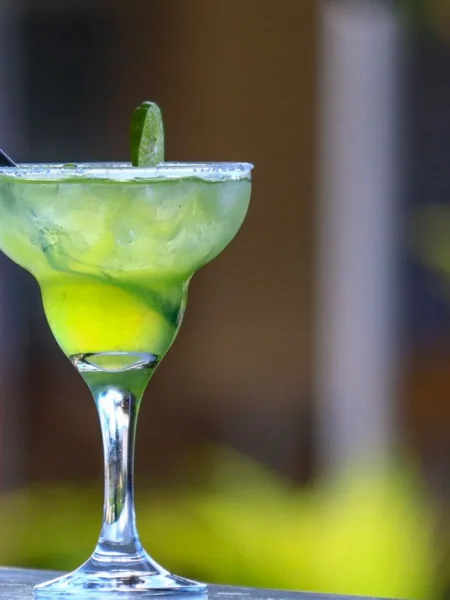 limoncello margarita mocktail in a salt-rimmed glass with lemon wheel and fizzy citrus liquid