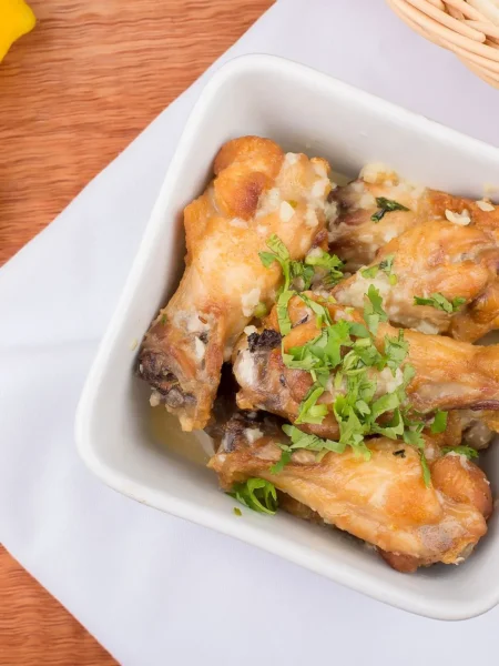 marinated baked chicken recipe with golden crispy skin, lemon garlic herbs, on a parchment lined tray
