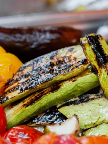 mediterranean roasted vegetables recipe with zucchini, bell peppers, cherry tomatoes, and red onion on a sheet pan