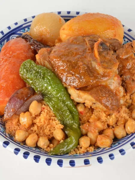 moroccan chicken and couscous skillet with seared chicken thighs, toasted couscous, apricots, and green olives in a pan