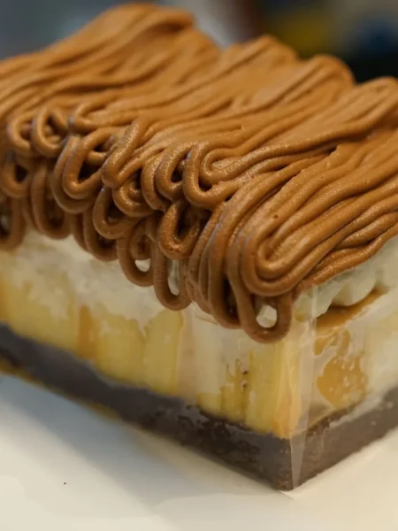 not your mamas banana pudding in a glass dish with brown butter cookie layers, banana slices, salted caramel, and mascarpone cream