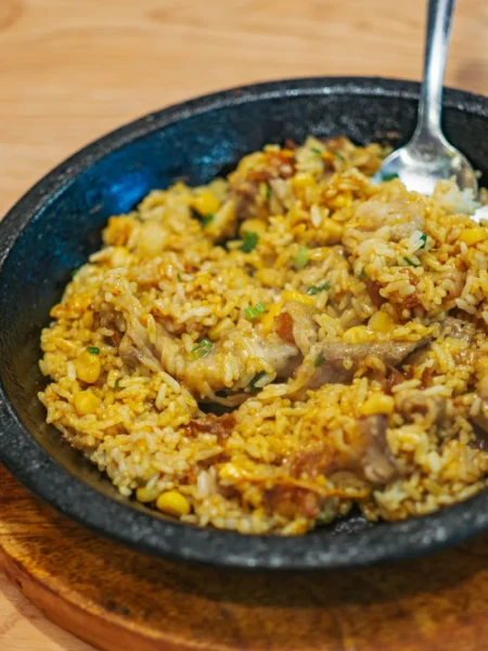 one pot chicken verde skillet with browned chicken thighs, tomatillo sauce, and white rice in a cast iron pan