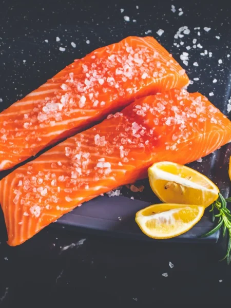orange glazed salmon recipe with sticky caramelized orange glaze on broiled skin-on fillets served on a foil tray