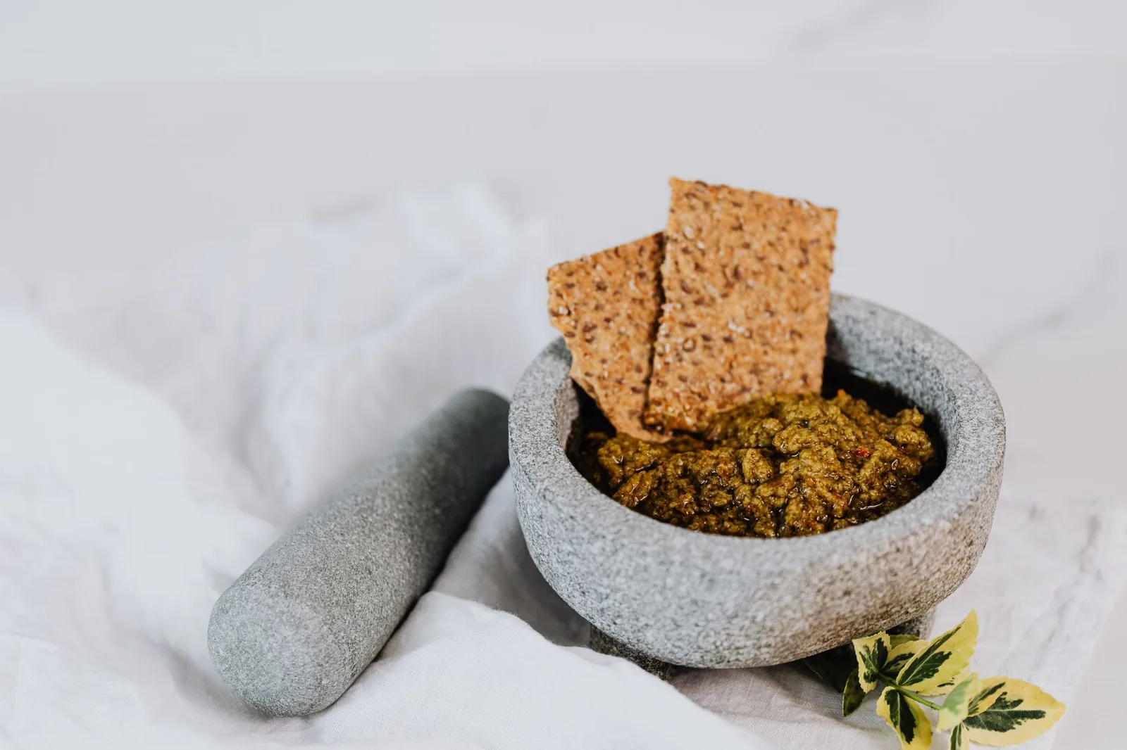 bowl of green pesto without nuts with basil and oil drizzle