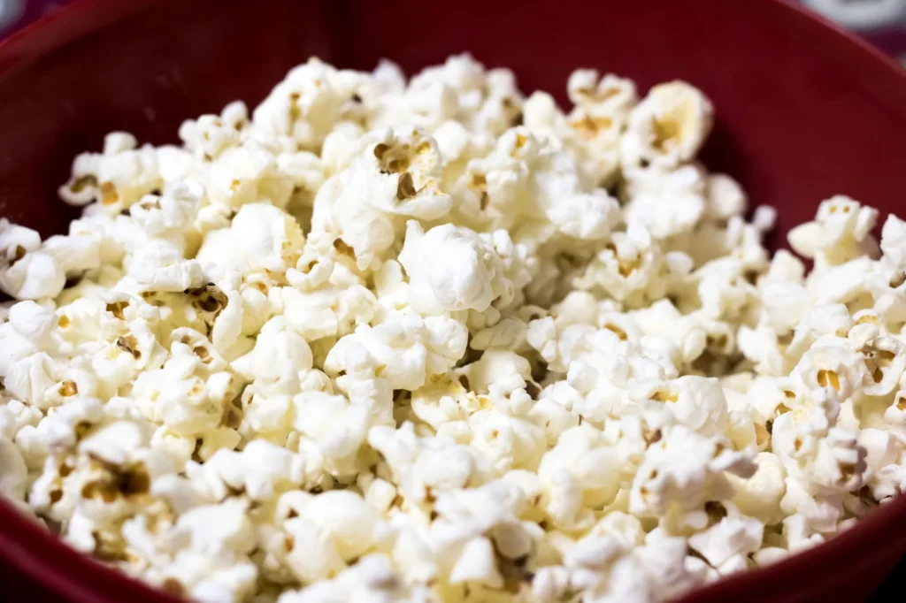 popcorn seasoning recipe ideas for snacking with golden air-popped corn tossed in smoky paprika and nutritional yeast on a white bowl