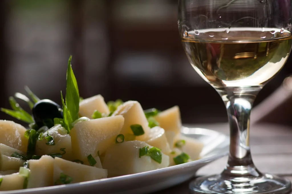 potato green bean salad with cubed yellow potatoes and bright green beans tossed in a clear mustard vinaigrette in a white bowl