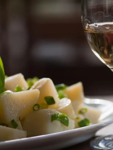 potato green bean salad with cubed yellow potatoes and bright green beans tossed in a clear mustard vinaigrette in a white bowl