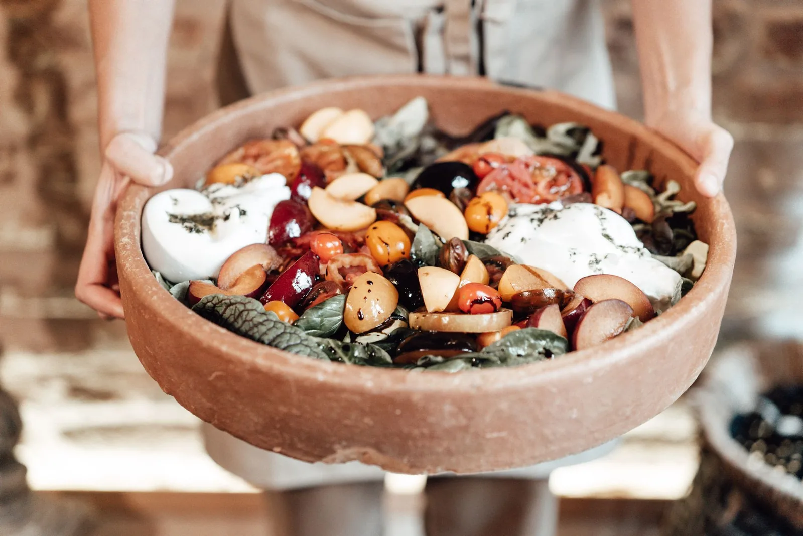 plate of proscuitto burrata and grilled peach salad with arugula and ham