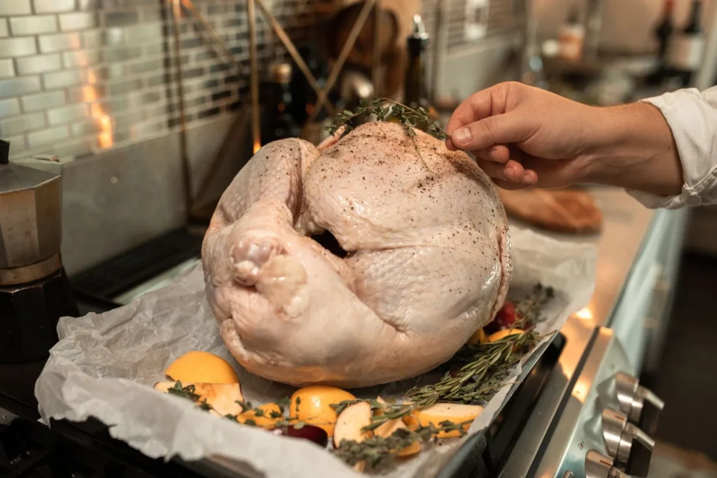 roast turkey recipe with golden crisp skin, lemon and herb butter, carved breast on a rimmed pan