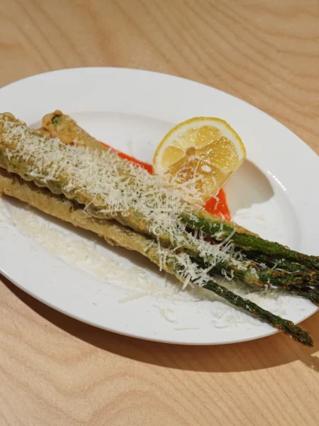 roasted asparagus with crispy parmesan showing golden cheese crust on tender green spears on a sheet pan