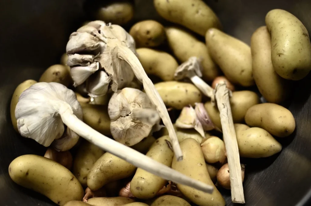 smashed fingerling potatoes recipe with golden crisp edges, parmesan, and rosemary on a dark tray