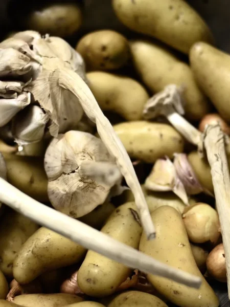 smashed fingerling potatoes recipe with golden crisp edges, parmesan, and rosemary on a dark tray
