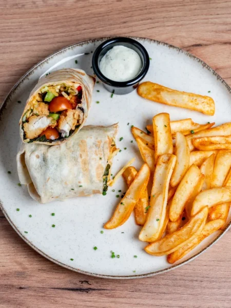 southwest chicken wrap recipe for lunch with seared chicken strips, black beans, corn, and melted cheddar in a rolled flour tortilla
