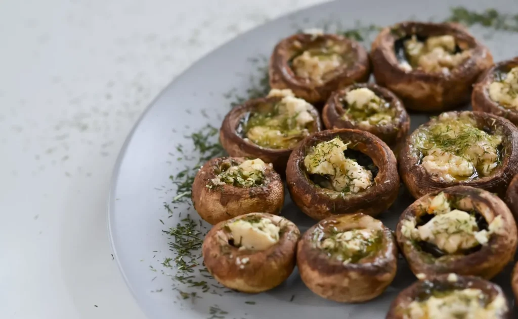 stuffed mushroom recipe for parties with cremini caps filled with golden cheese herb breadcrumb topping on a tray