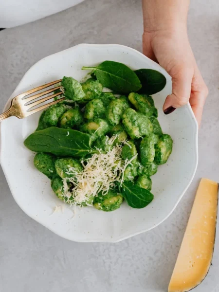 turkey spinach meatballs recipe with golden seared turkey balls, chopped spinach, and parmesan on a white plate